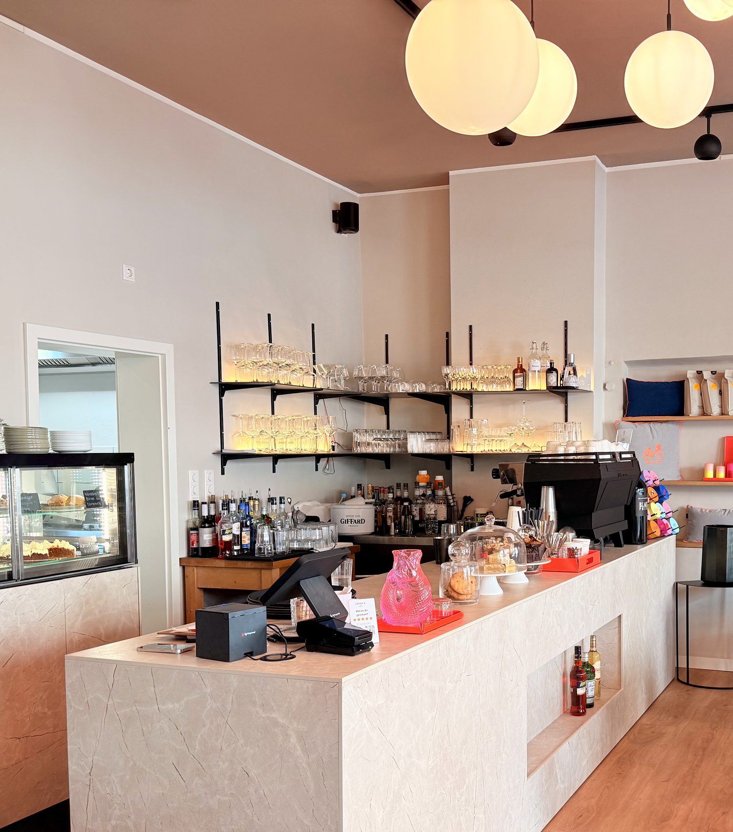 Marmortresen des LunaVia mit Espressomaschine, Kuchenauslage und Regalen